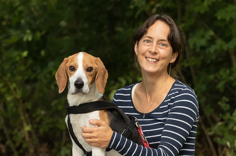 Preisträgerin Dr. Claudia Ruf lächelt in die Kamera, daneben sitzt Hund Charlie